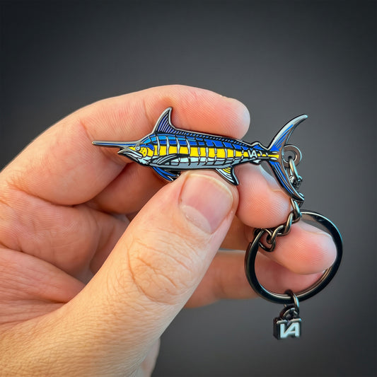 Blue Marlin keychain held in hand against a dark background