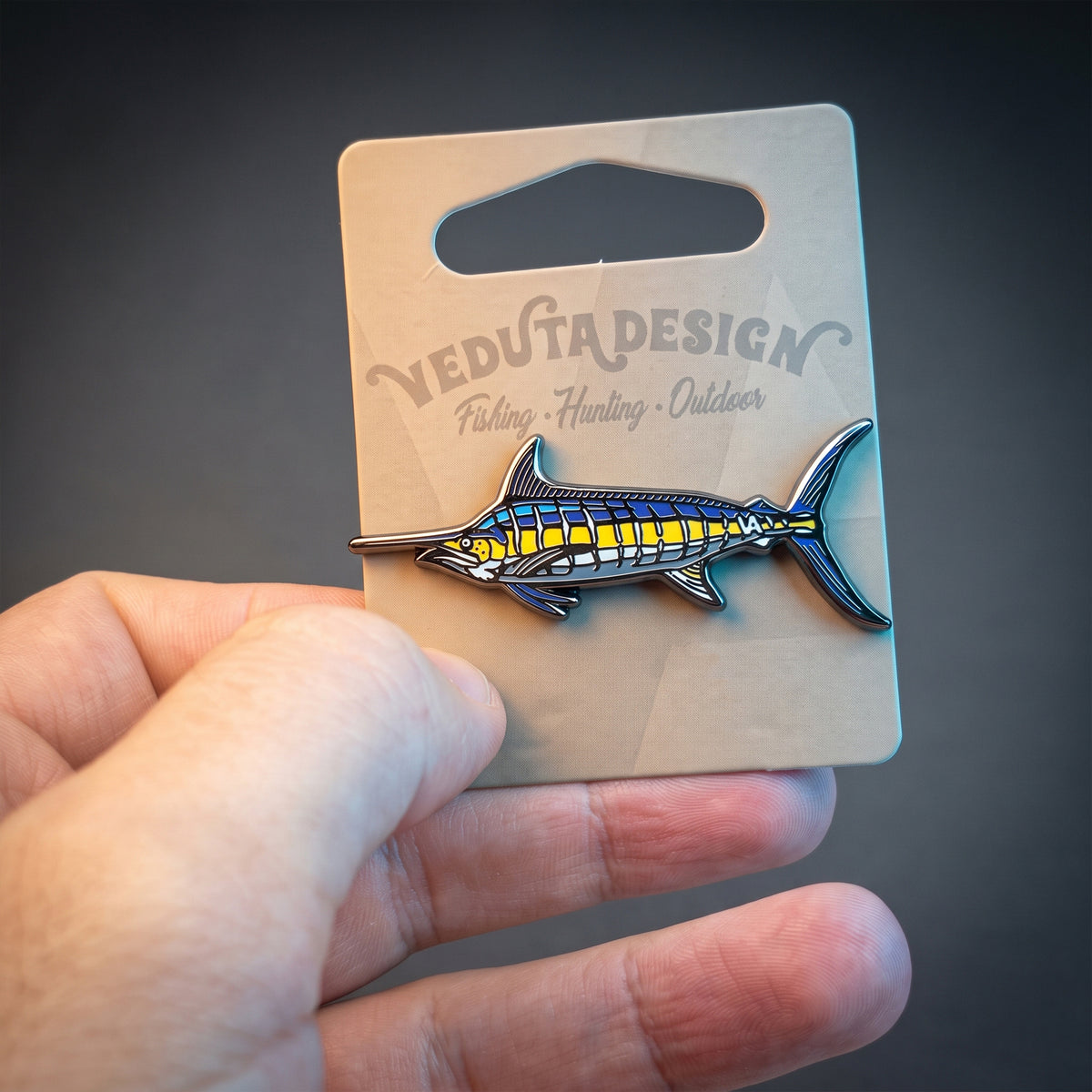 Blue Marlin pin on VEDUTA DESIGN branded backing card held in hand