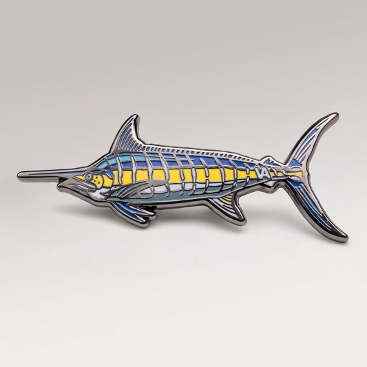 Black nickel Blue Marlin pin with blue and yellow enamel on a light studio background
