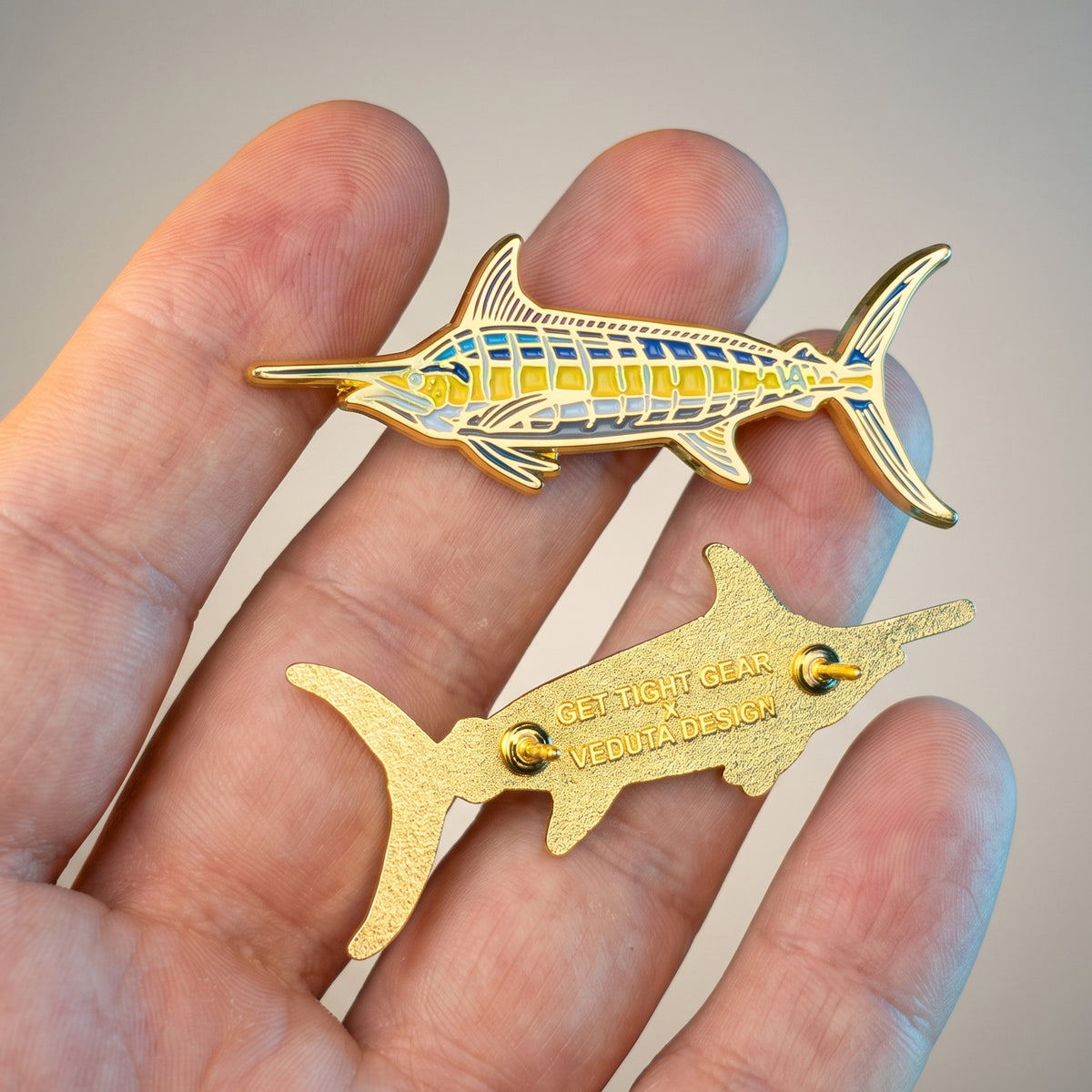 Blue Marlin pin held in hand with a separate clutch back piece