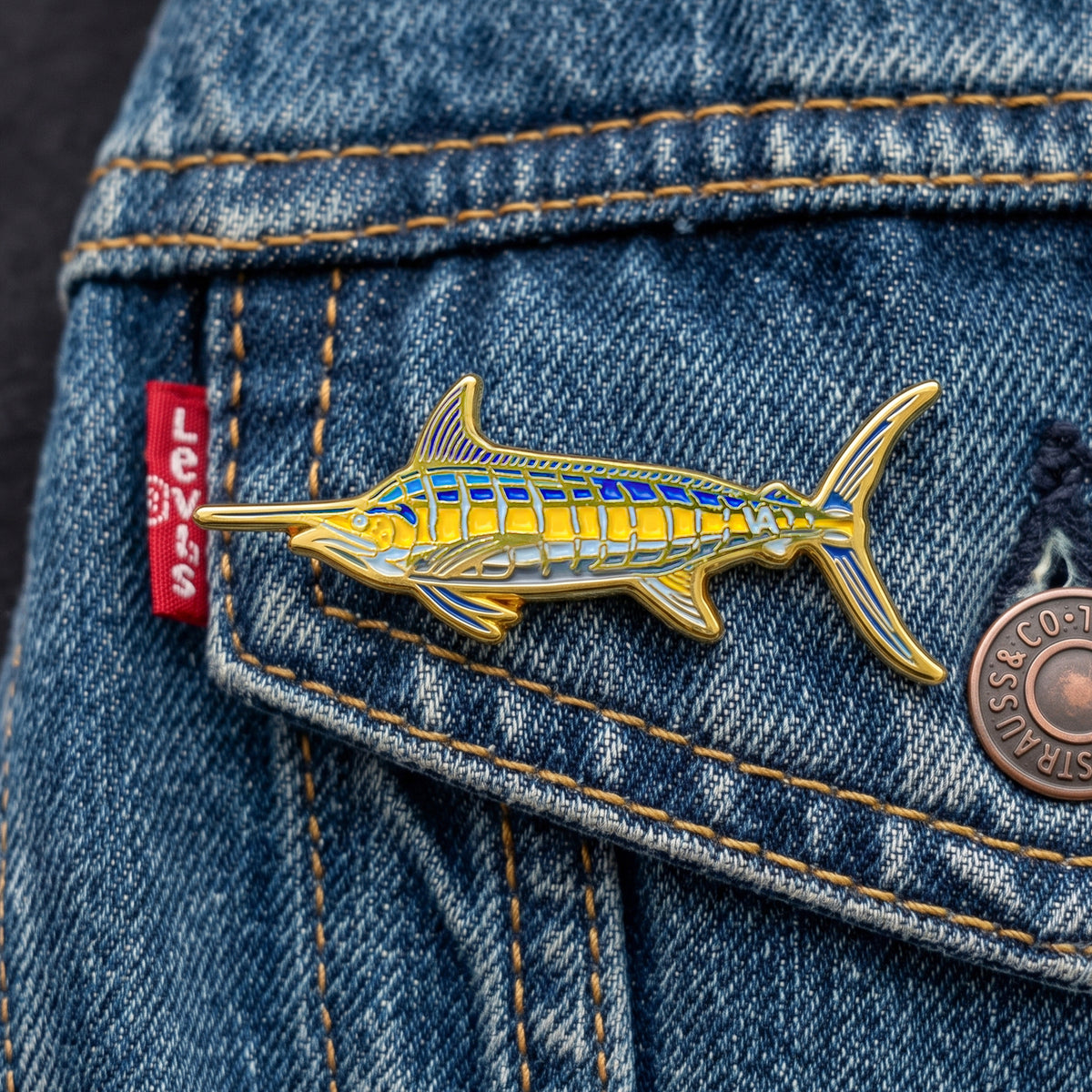 Blue Marlin pin on a denim jacket pocket
