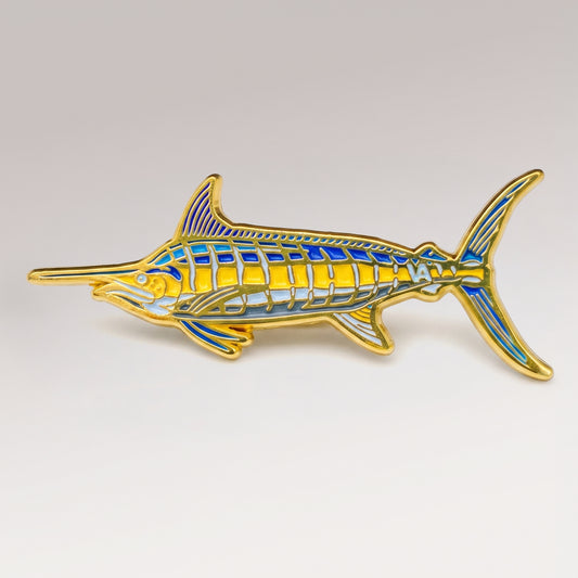 Gold and blue enamel Blue Marlin pin on a light studio background