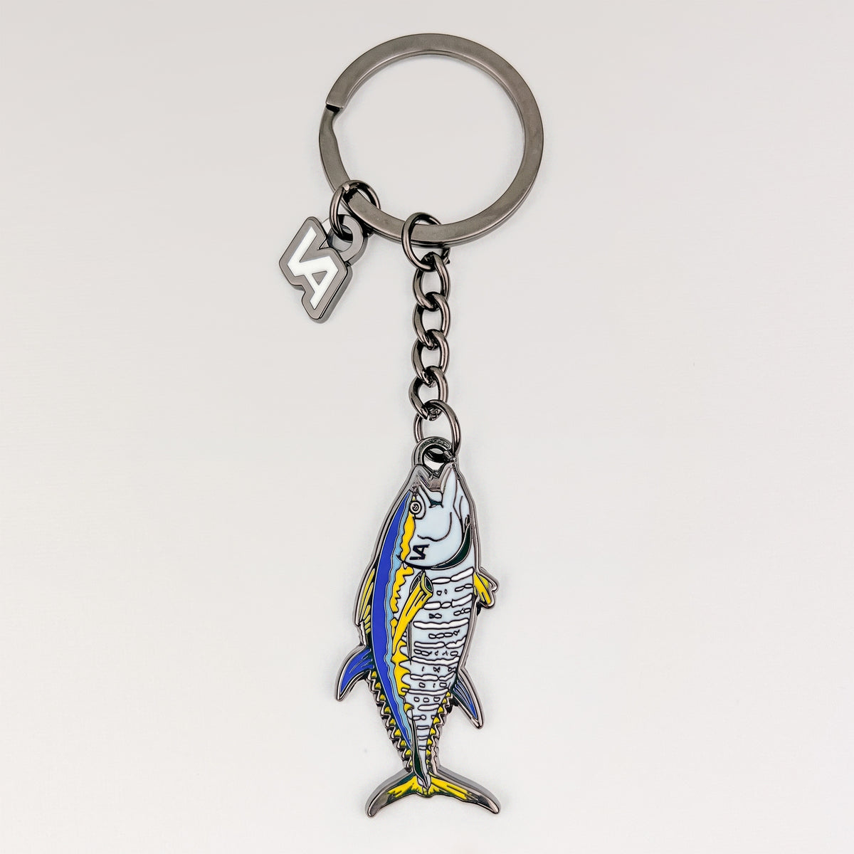 Bluefin Tuna keychain, black nickel hard enamel charm with the VEDUTA DESIGN VA logo charm and chain, on a light studio background