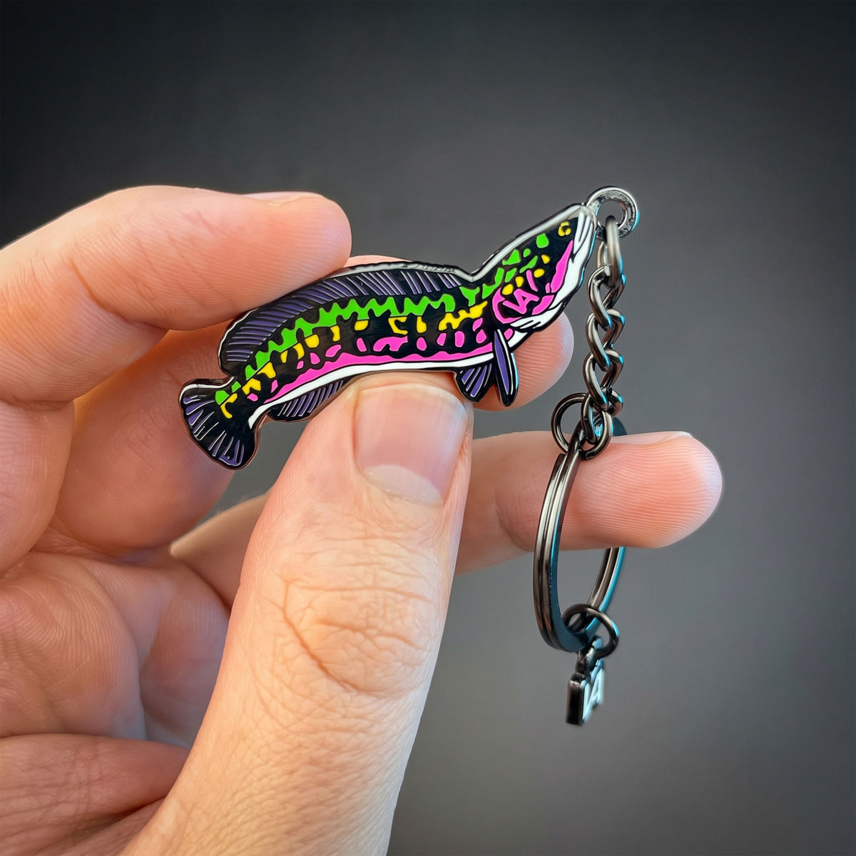 Giant Snakehead keychain held in hand against a dark background