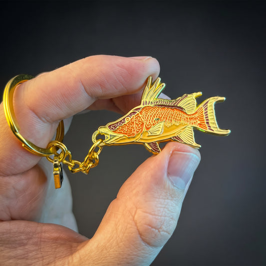 Hogfish keychain held in hand against a dark background