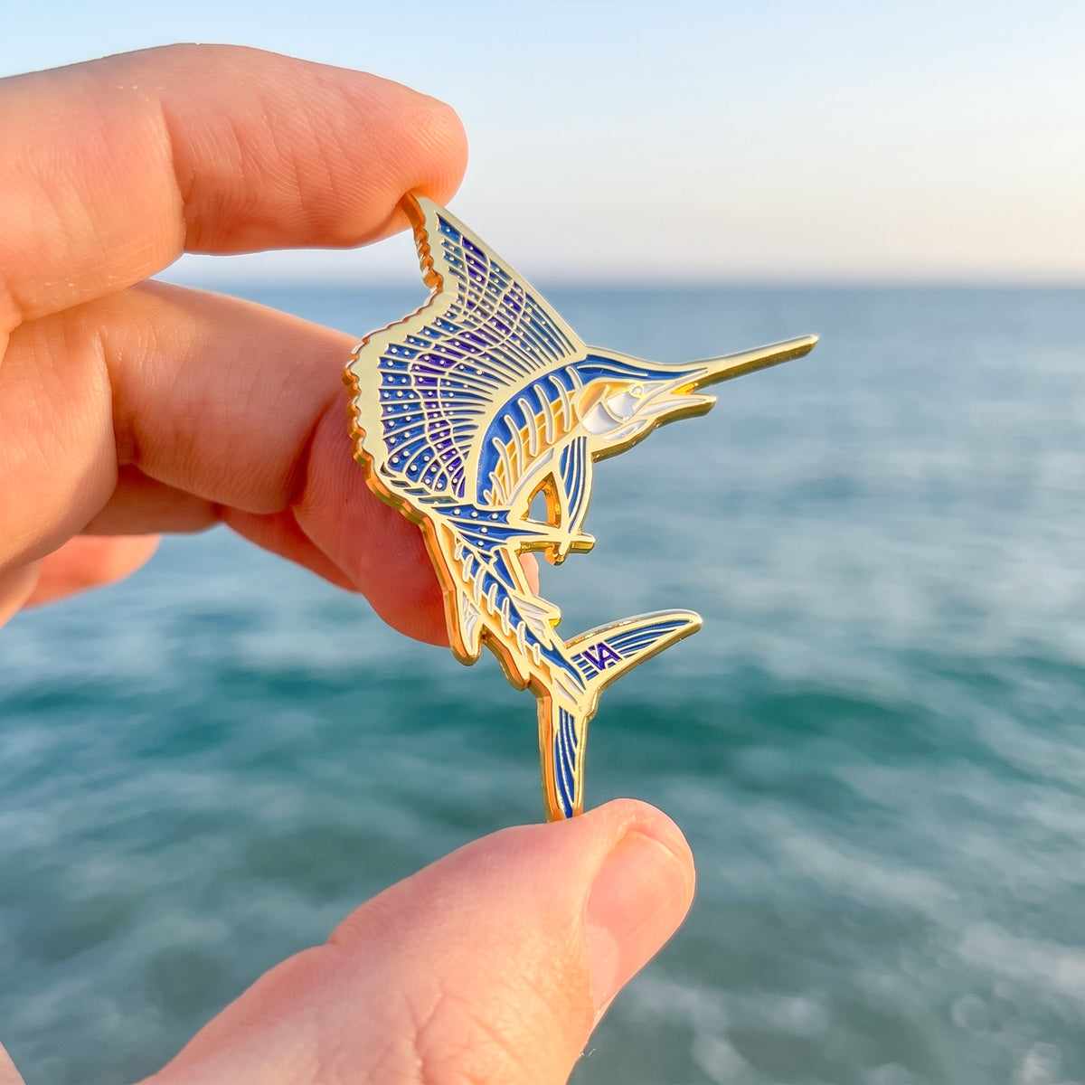 Sailfish enamel pin detail with ocean background