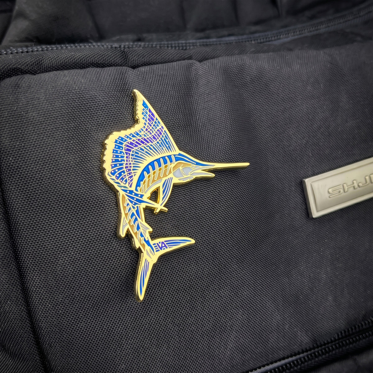 Sailfish pin attached to a canvas tackle bag