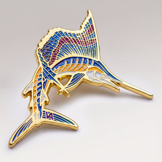 Gold and blue enamel Leaping Sailfish pin on a light studio background