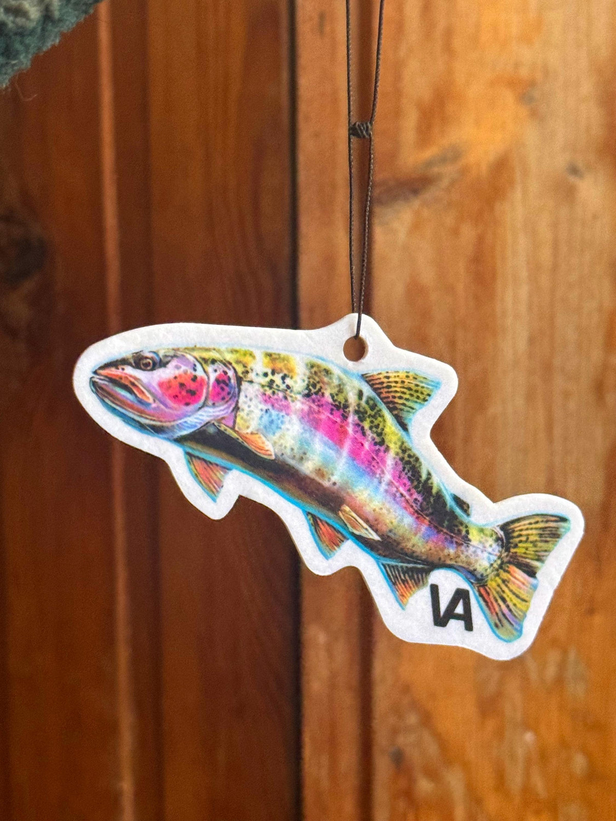 Rainbow Trout air freshener hanging against a wooden wall
