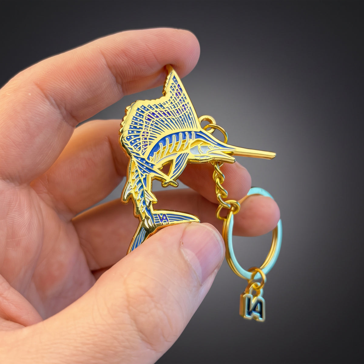 Leaping Sailfish keychain held in hand against a dark background