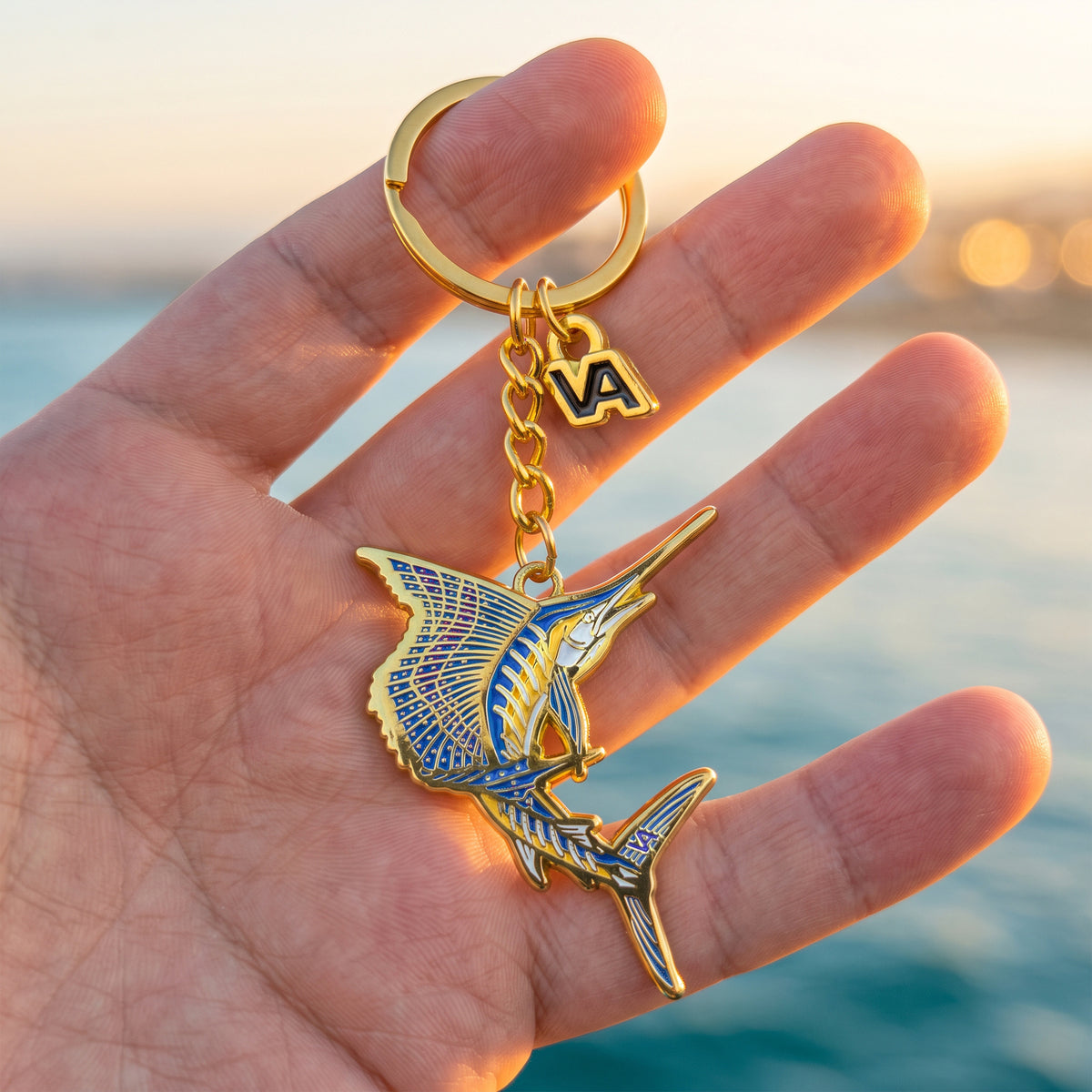 Leaping Sailfish keychain held in hand with the ocean in the background