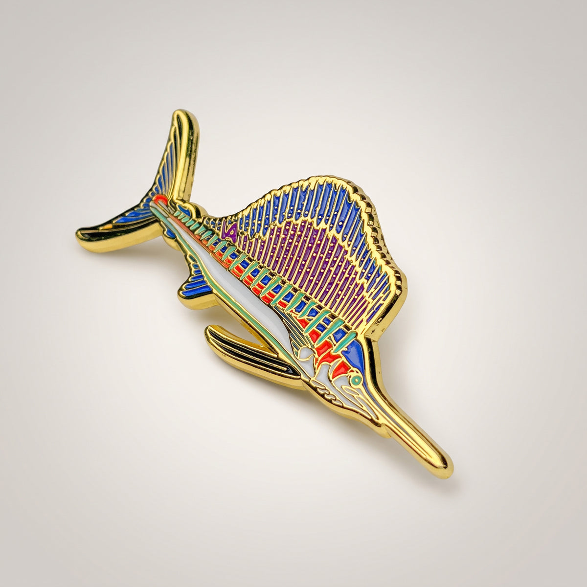 Gold and purple Sailfish pin on a warm studio background, angled view