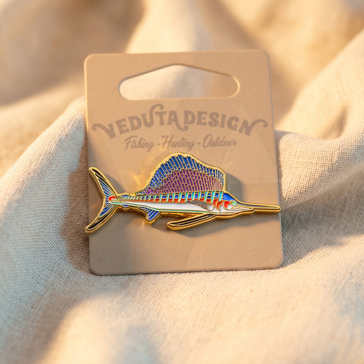 Sailfish pin on branded packaging card, laid flat on fabric