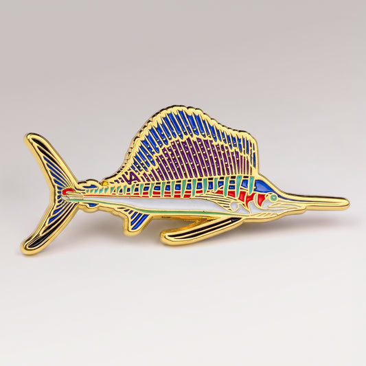 Gold and purple enamel Sailfish pin, profile design, on a white studio background