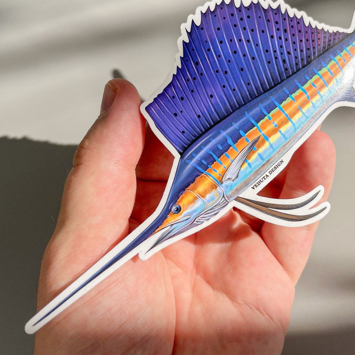 Close-up of Sailfish sticker held in hand