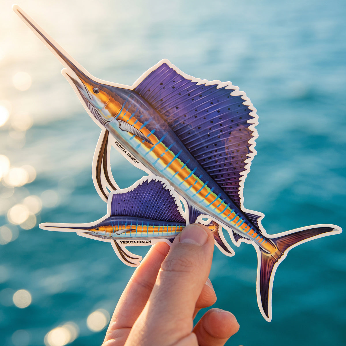 Sailfish sticker held in hand with the ocean in the background