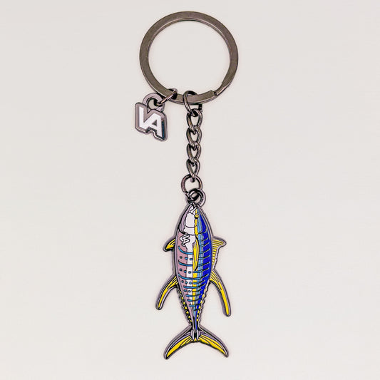 Yellowfin Tuna keychain, black nickel hard enamel charm with the VEDUTA DESIGN VA logo charm and chain, on a light studio background