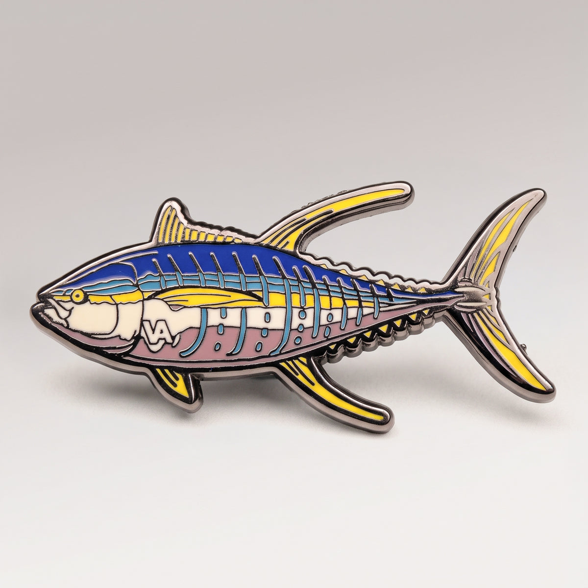 Blue and yellow enamel Yellowfin Tuna pin on a light studio background