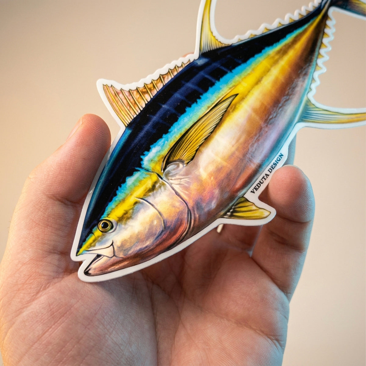 Yellowfin Tuna sticker held in hand against a warm, light background
